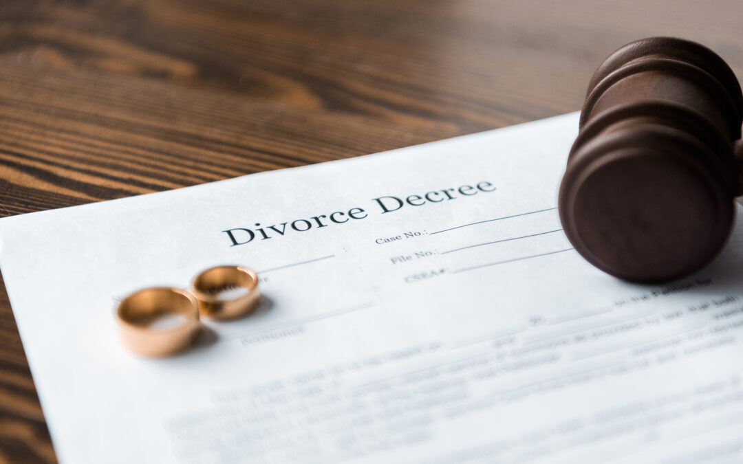 image of divorce decree, wedding rings and wooden hammer